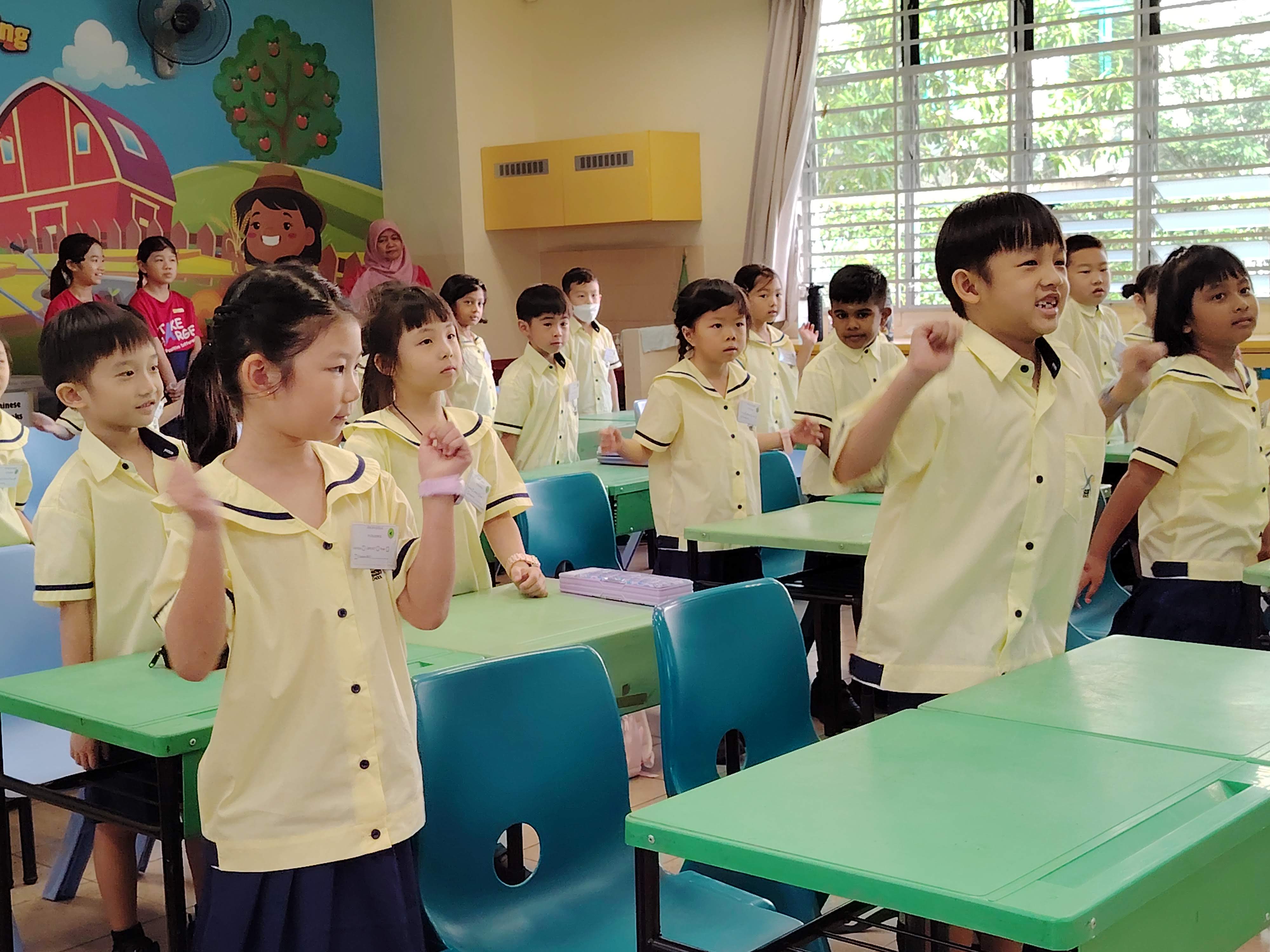 P1 students in class enjoying a classroom activity - singing together